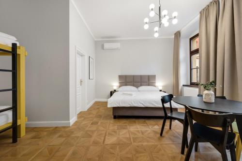 a bedroom with a bed and a table and a dining room at Palace Apartments in Bratislava