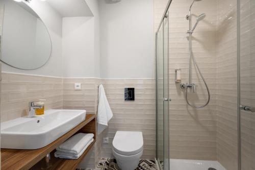 a bathroom with a shower and a toilet and a sink at Palace Apartments in Bratislava