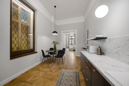 a kitchen and dining room with a table and chairs at Palace Apartments in Bratislava