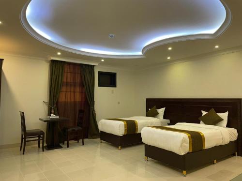 a hotel room with two beds and a circular ceiling at Arrawiya Alzahabia Hotel in Dammam