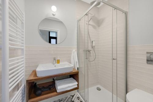 a white bathroom with a sink and a shower at Palace Apartments in Bratislava