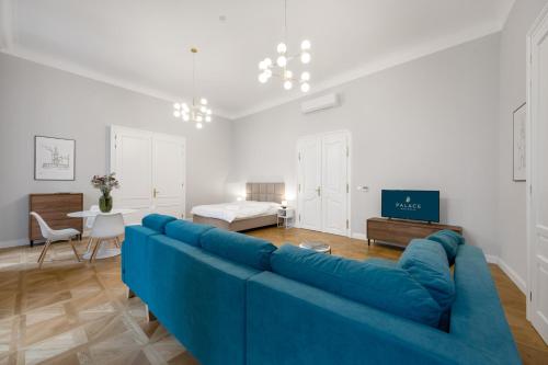 a blue couch in a living room with a bed at Palace Apartments in Bratislava