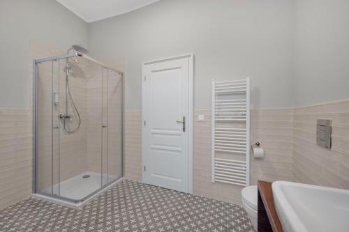 a bathroom with a shower and a toilet and a sink at Palace Apartments in Bratislava