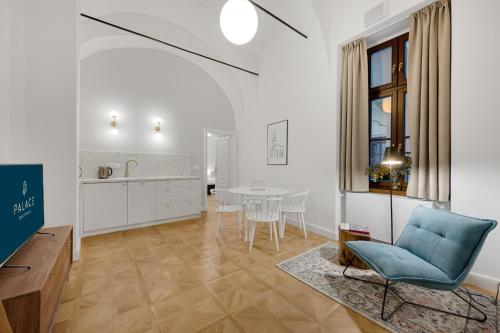 a living room with a table and a blue chair at Palace Apartments in Bratislava