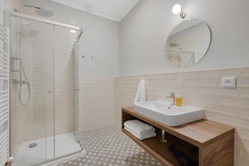 a white bathroom with a sink and a shower at Palace Apartments in Bratislava