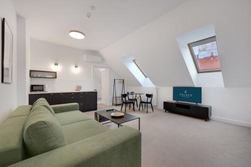 a living room with a green couch and a table at Palace Apartments in Bratislava