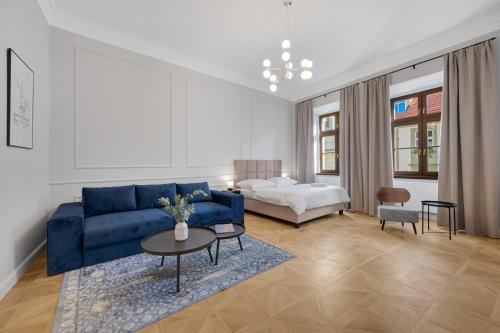 a living room with a blue couch and a bed at Palace Apartments in Bratislava
