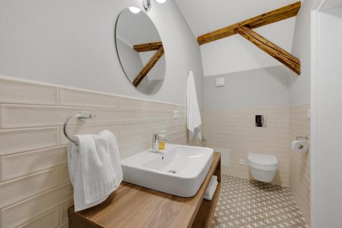 a bathroom with a white sink and a mirror at Palace Apartments in Bratislava