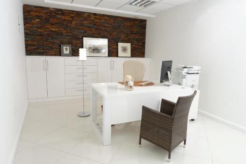 an office with a white desk and a chair at ApartHotel Vila Minka in Ljubljana