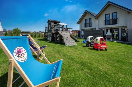 a yard with a playground with a chair and a slide at Chłapowska Przystań in Władysławowo