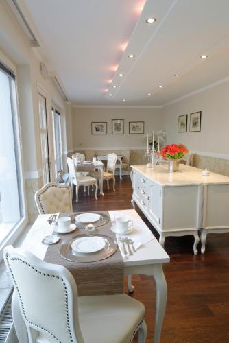 a dining room with a white table and chairs at ApartHotel Vila Minka in Ljubljana