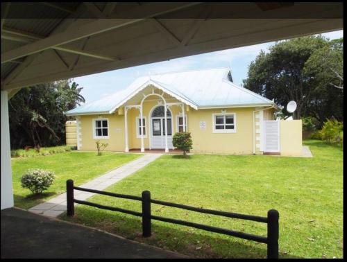 a yellow house with a fence in front of it at Caribbean Estates Villa Caylee - Ultra-Luxurious - Rimas Interiors Designs - Private Beachfront Escape - Premium serviced for 8 Guests in Port Edward