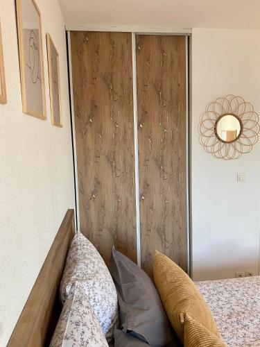 a bedroom with a wooden door with pillows on a bed at Appartement en face Hopital Nord in Saint-Priest-en-Jarez