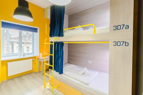 a room with two bunk beds with a window at Stories Hub in Lviv