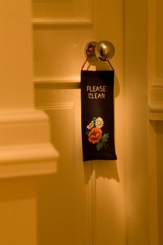 a bag hanging on a door with the words please clean at Pädaste Manor in Pädaste