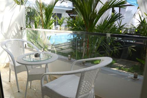 a table and chairs on a balcony with plants at La Vera Boutique Hotel, Mandrem in Mandrem