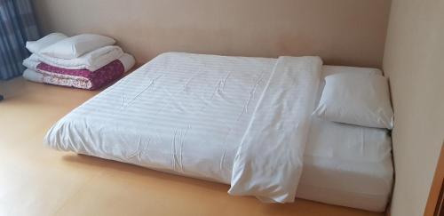 a bed with white sheets and a pile of towels at Daegu Grand Hotel in Daegu
