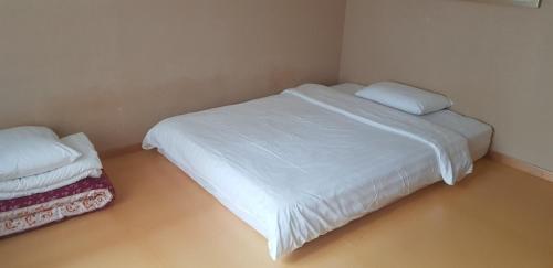 a small bedroom with a white bed and a pillow at Daegu Grand Hotel in Daegu