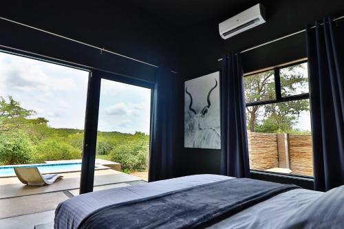 a bedroom with a bed and a large window at Umkhaya in Marloth Park