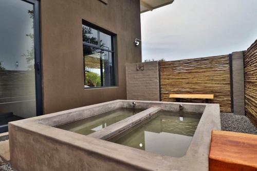 a large bath tub in the corner of a house at Umkhaya in Marloth Park