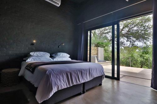 a bedroom with a large bed with white sheets and pillows at Umkhaya in Marloth Park