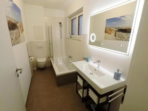 a bathroom with a sink and a tub and a toilet at -Neubau- 68 qm 2-Zimmer-Wohnung in Fulda