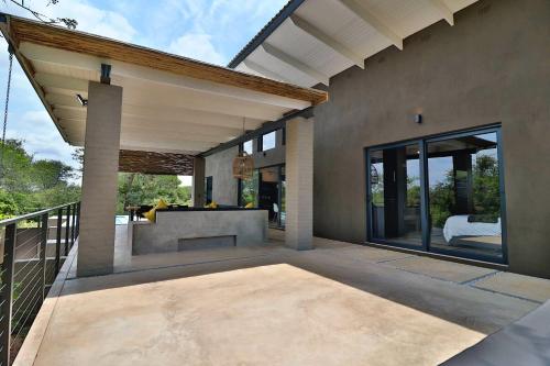 a patio of a home with glass doors and a balcony at Umkhaya in Marloth Park