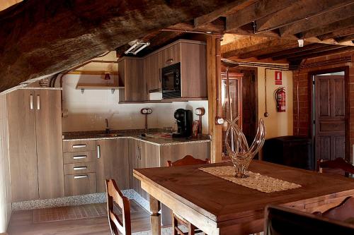 cocina con mesa de madera en una habitación en Casa Josefita en Villamayor