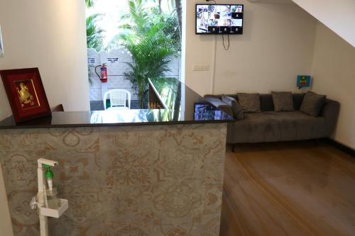 a living room with a couch and a tv at La Vera Boutique Hotel, Mandrem in Mandrem
