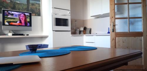 a kitchen with a wooden table with blue cushions at SportApartment Wabnig in Moosburg