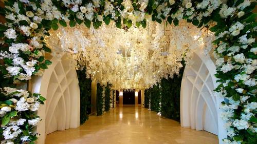 a corridor with white flowers and a chandelier at Jewel Sport City and Aqua Park in Cairo