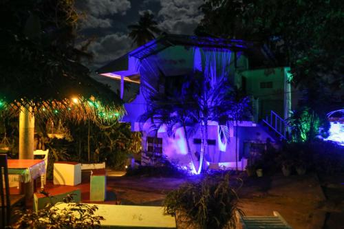 a house with purple lights on it at night at Sajana Ocean Hill in Mirissa