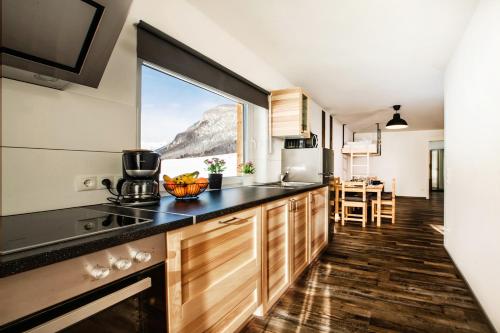 een keuken met een groot raam met uitzicht op een berg bij Fischer Ferienhaus in Tweng