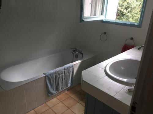 een badkamer met een wastafel, een bad en een wastafel bij Maison 100 m plage, 2 kms du port in L'Ile d'Yeu