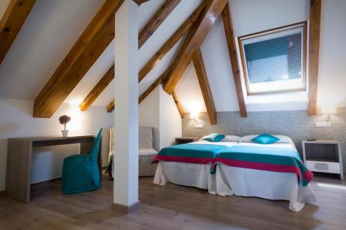 - une chambre mansardée avec un grand lit dans l'établissement Hotel Rural Auñamendi, à Ochagavía