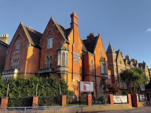 a large brick building with a sign in front of it at The Corner House Hotel in Taunton