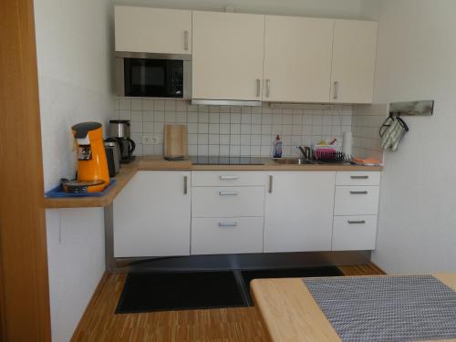 a kitchen with white cabinets and a counter top at Ferienwohnung Mattenweg 1a in Hinterzarten