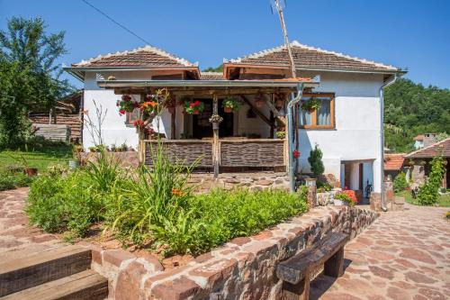 una casa con una pared de piedra delante de ella en Seosko domaćinstvo „GABAR” en Ćuštica