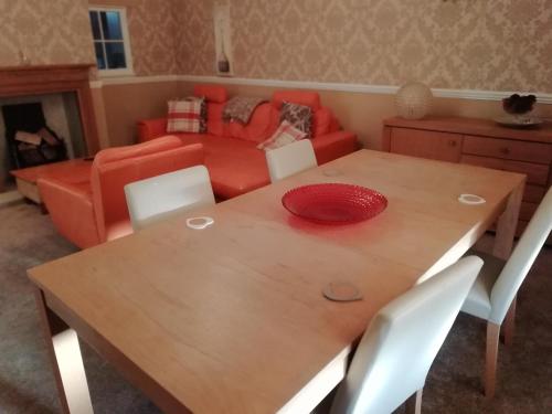 a dining room table with a red plate on top at Carvetii - Halite House - 3 bed House sleeps up to 5 people in Tillicoultry