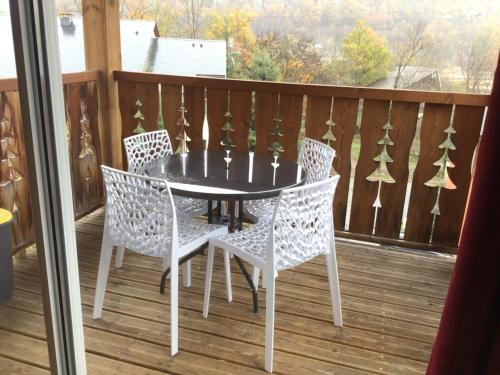 a table and chairs on a deck with a view at Les Reflets d'Ax in Ax-les-Thermes