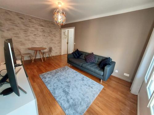 a living room with a couch and a table at Bel appartement 2 pièces, sortie de métro ligne 8 in Charenton-le-Pont