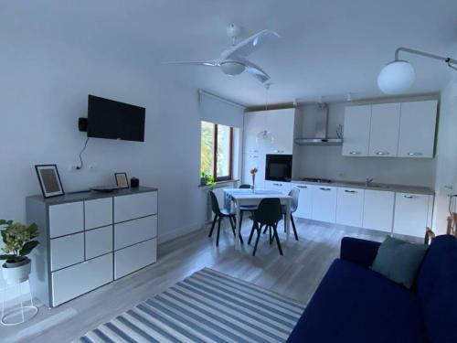 a kitchen and a living room with a table and chairs at Garda View Apartment in Tenno