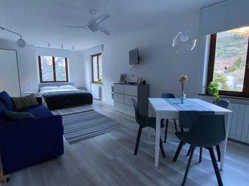 a living room with a table and a bedroom at Garda View Apartment in Tenno