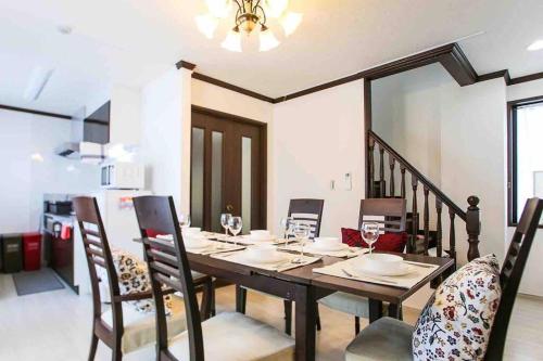 a dining room with a wooden table and chairs at Guest house 華音 in Tokyo