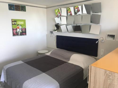 - une chambre avec un lit et des étagères sur le mur dans l'établissement Blue Beach Studio, au Cap d'Agde