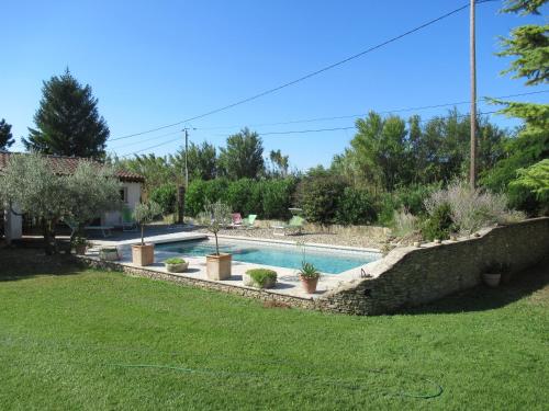 a swimming pool in a yard with a landscaping at LA MASTRONA in Saumane-de-Vaucluse