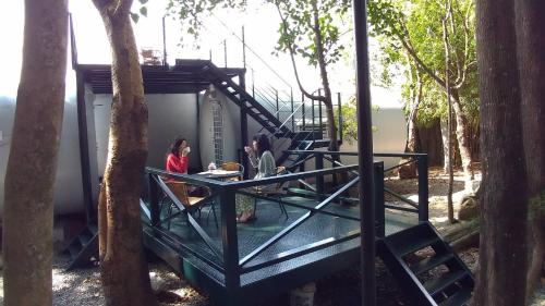 two people sitting at a table in a tree house at Meinong Yun Shanju Homestay in Meinong