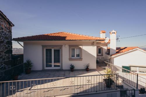 a white house with a balcony with a fence at Cabanelas Country House - Casa do Luís in Vale de Cambra