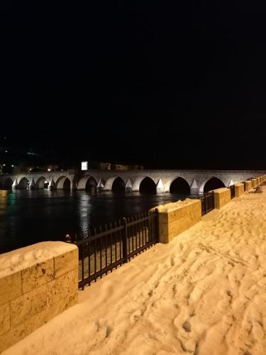 a bridge over a river at night with snow on the ground at Apartman Dukat in Višegrad