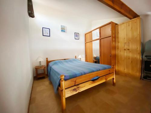 Un dormitorio con una cama y un armario de madera. en Appartement T2 mezzanine vue mer avec piscine, en Saint-Cyprien